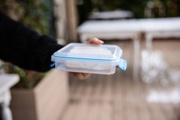 Businesswoman on lunch break eating a sandwich from a plastic box