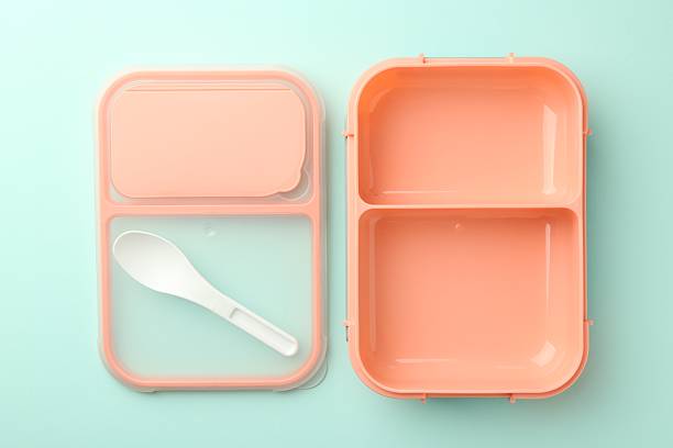 Empty lunch box with spoon on light blue background, flat lay